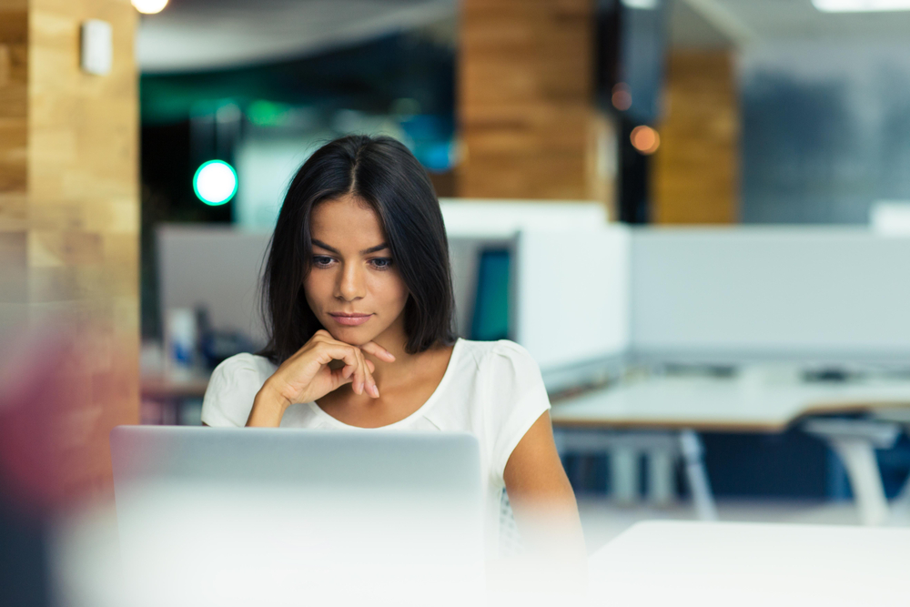 Portrait,Of,A,Serious,Businesswoman,Using,Laptop,In,Office